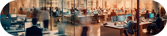 A busy office environment with multiple people collaborating at desks and engaging in discussions.