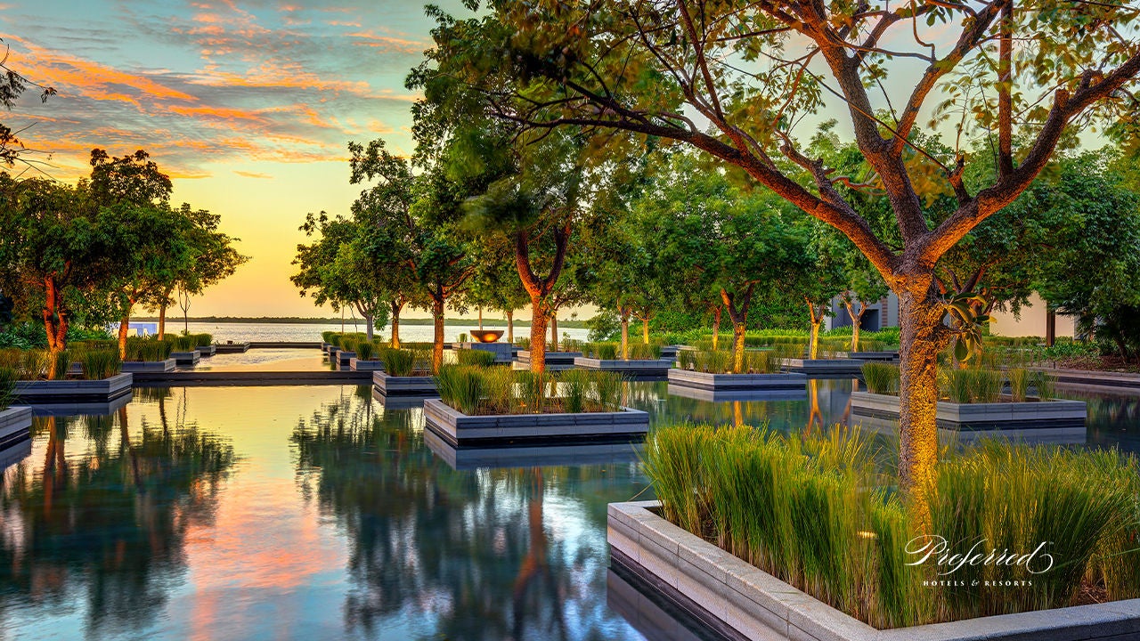 Location hotel con piscina a sfioro e aiuole in acqua al tramonto