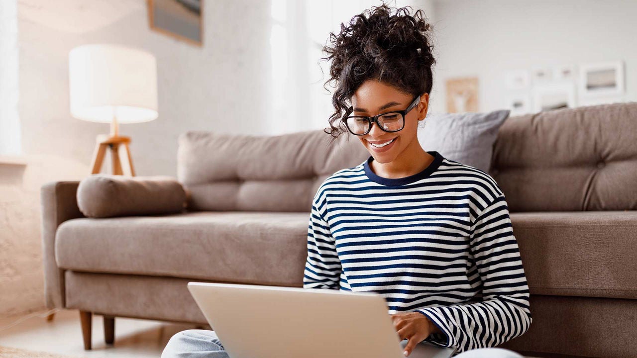 A woman sitting on a couch using a laptop