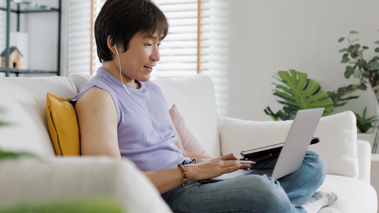 Man using a laptop on a couch.