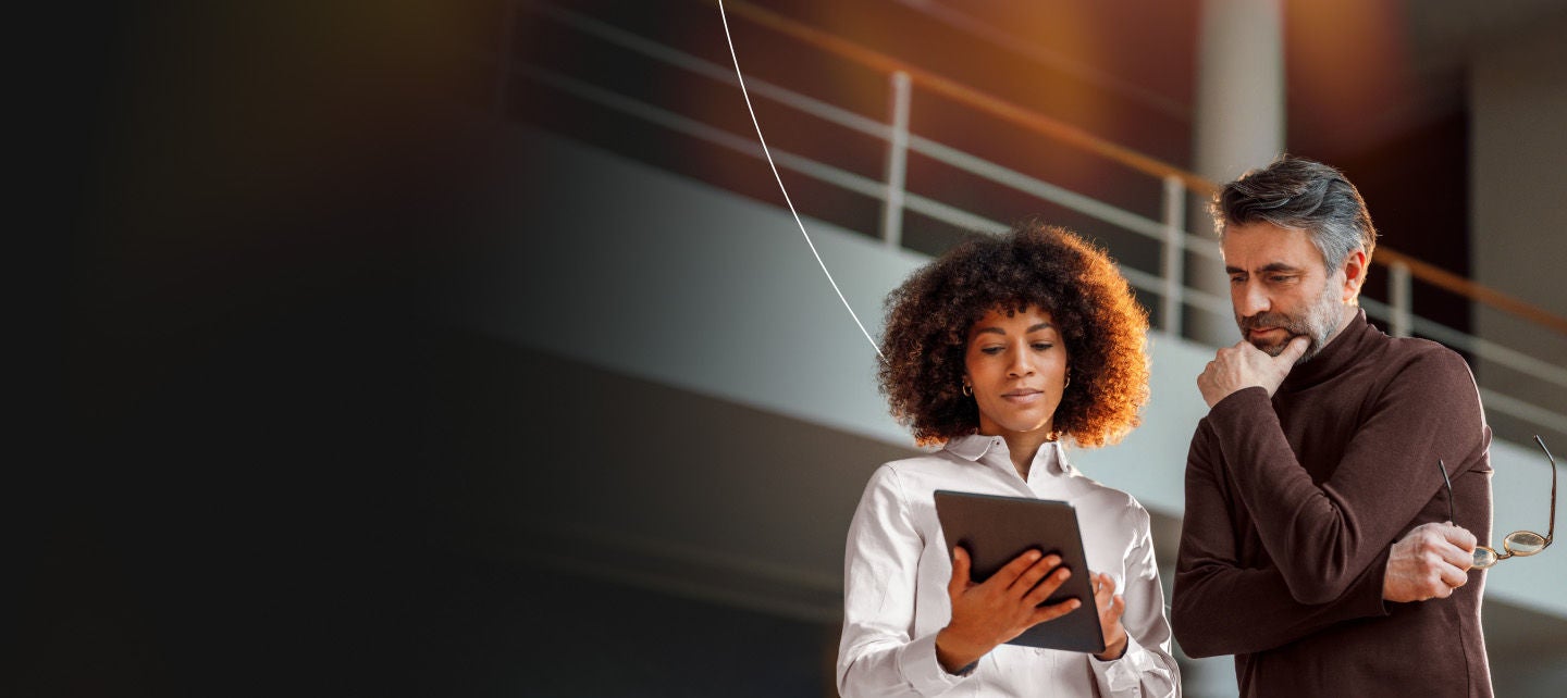 Man and woman looking pensively at a tablet
