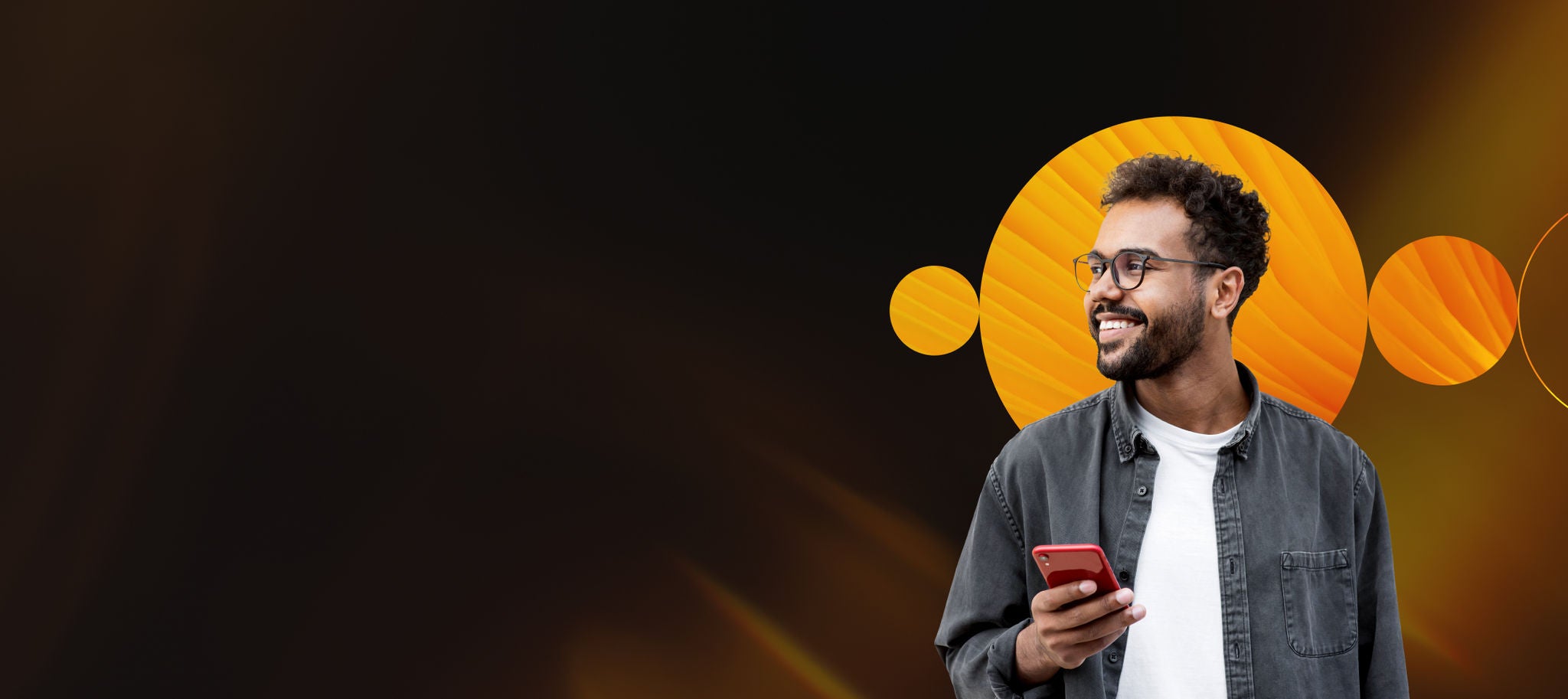 Man holding his phone smiling looking off into the distance