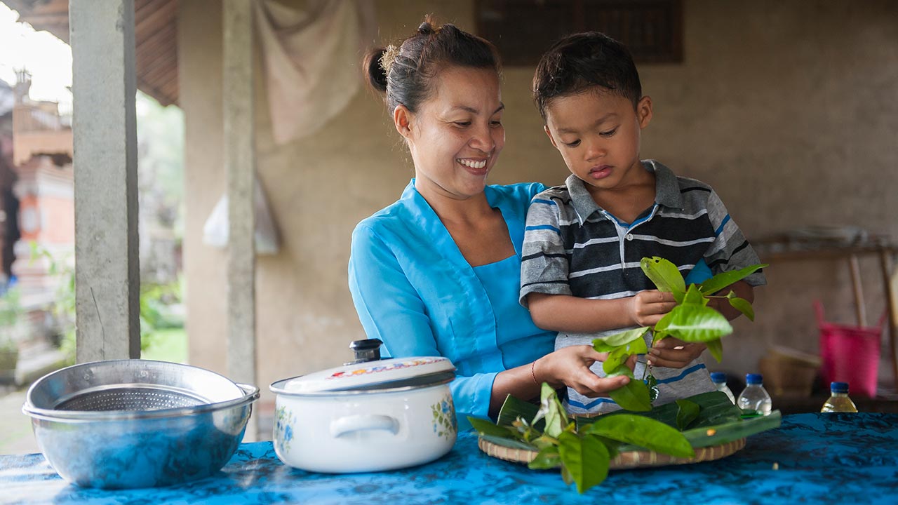 Asian mom and son preparing food outside