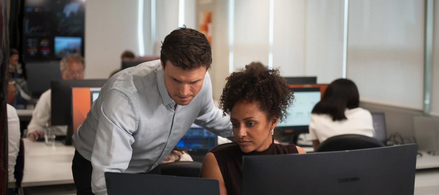 Man and woman reviewing a computer in an open office setting