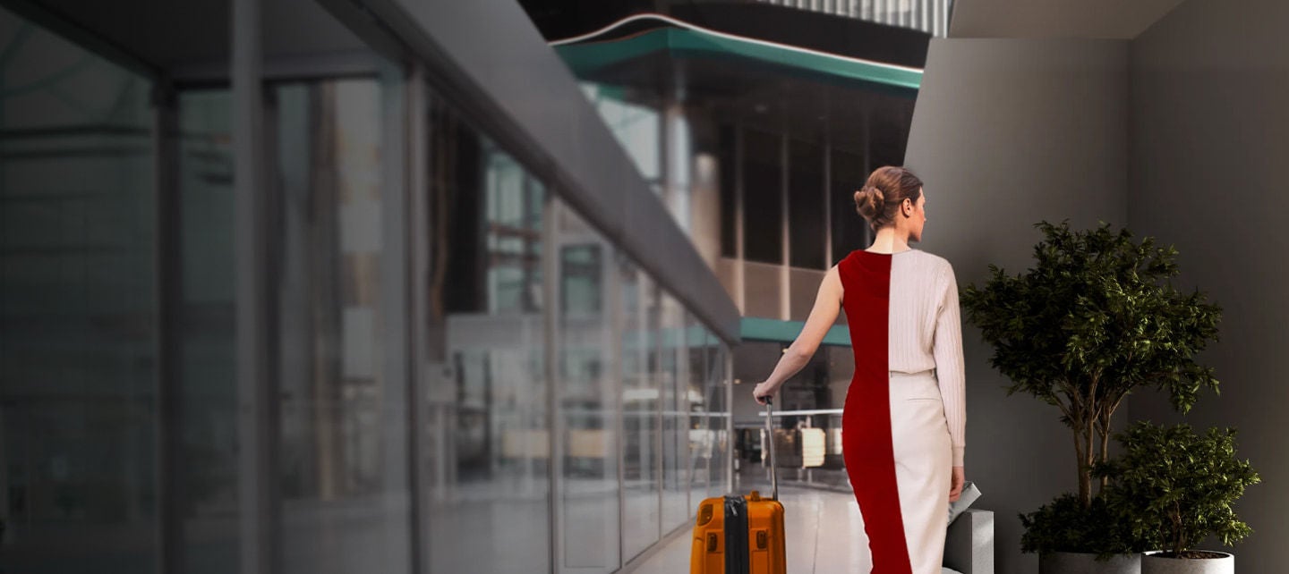 woman walking with orange suitcase