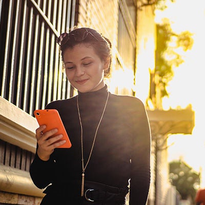 Woman smiling when looking at her phone.