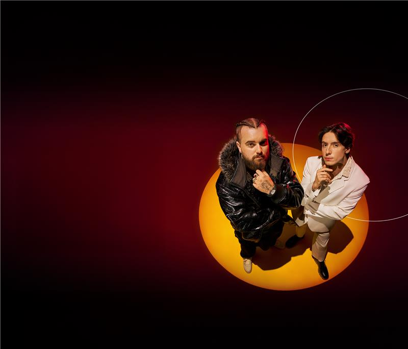 Stylowy duet pozuje w kontrastowym oświetleniu, z góry.