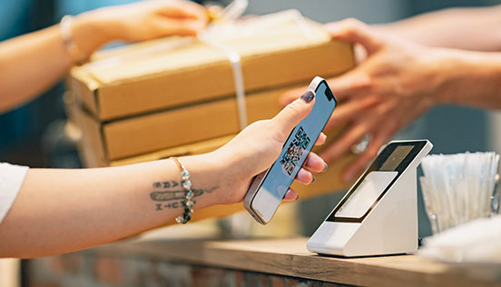 Jemand bezahlt mit einem QR-Code auf dem Mobiltelefon