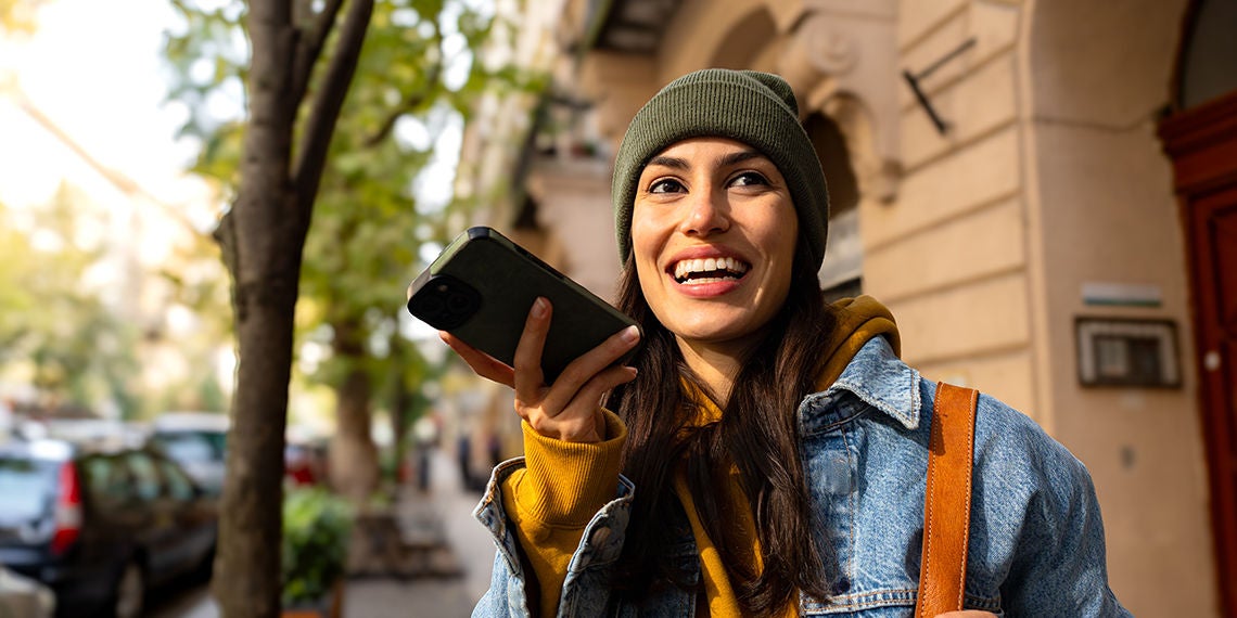 Woman talking on speaker phone outside