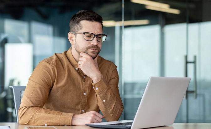 Man investigating fake accounts on his laptop