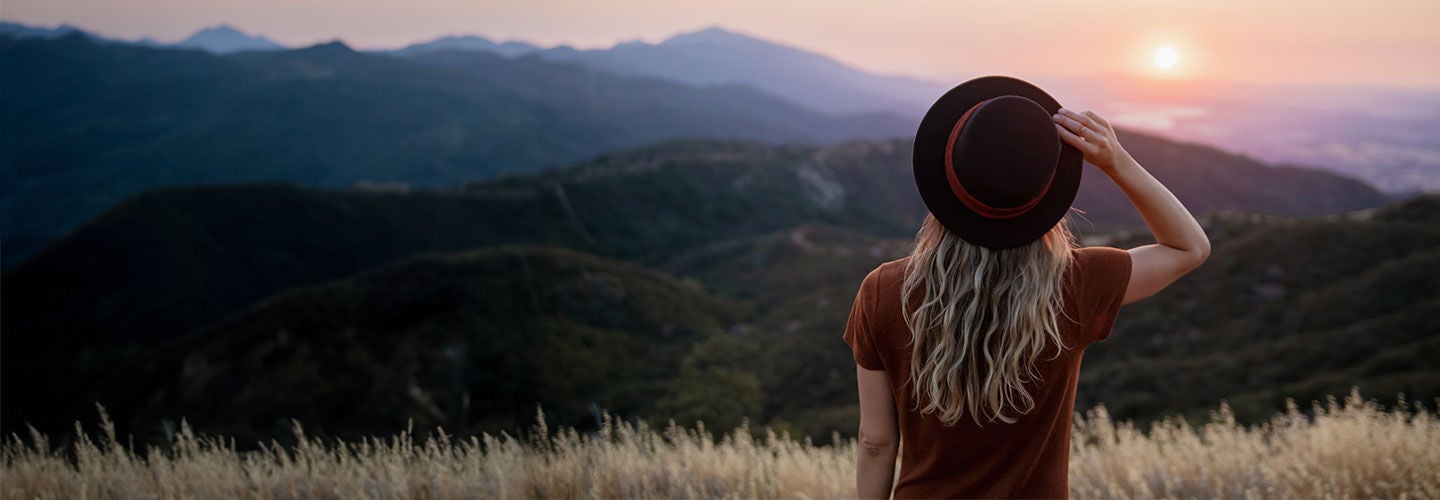Woman looking at sunset in the mountains