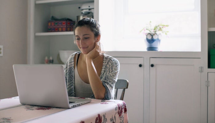 Junge Frau, die Laptop benutzt