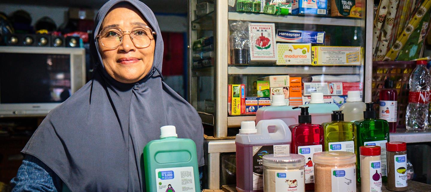 Nur Syamsiah håller en Alner-flaska i sin butik. 