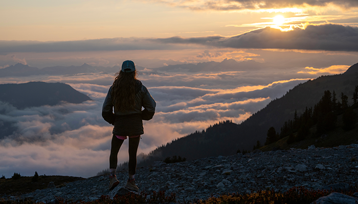 Woman looks over cloudscape from Mountain