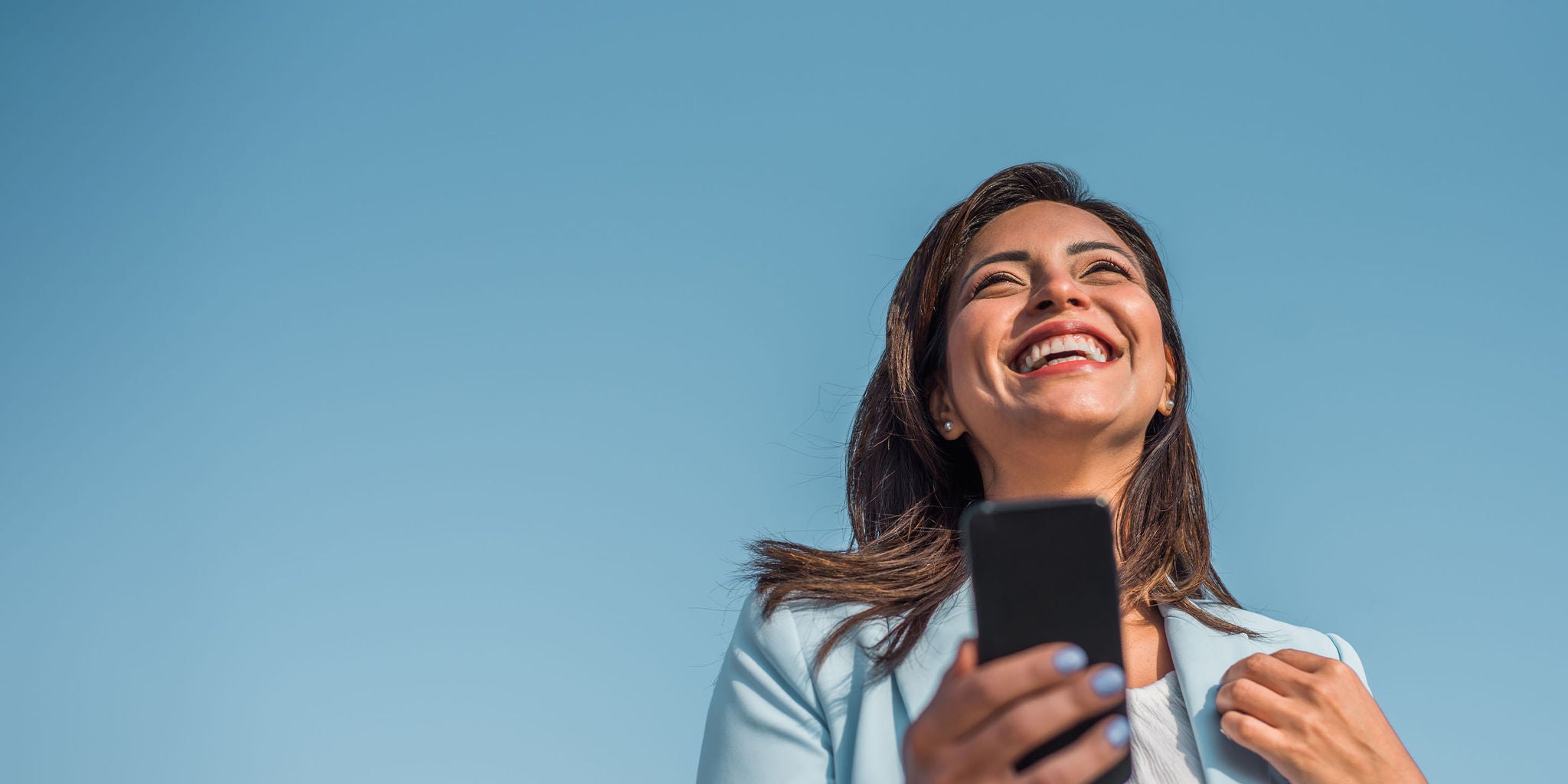 Woman smilying happyly using her phone