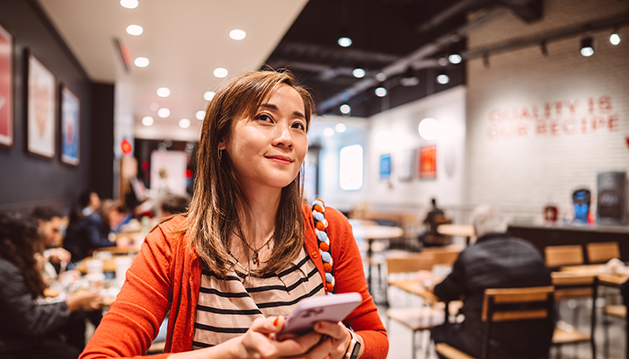 Woman using mobile app to order food at casual restaurant