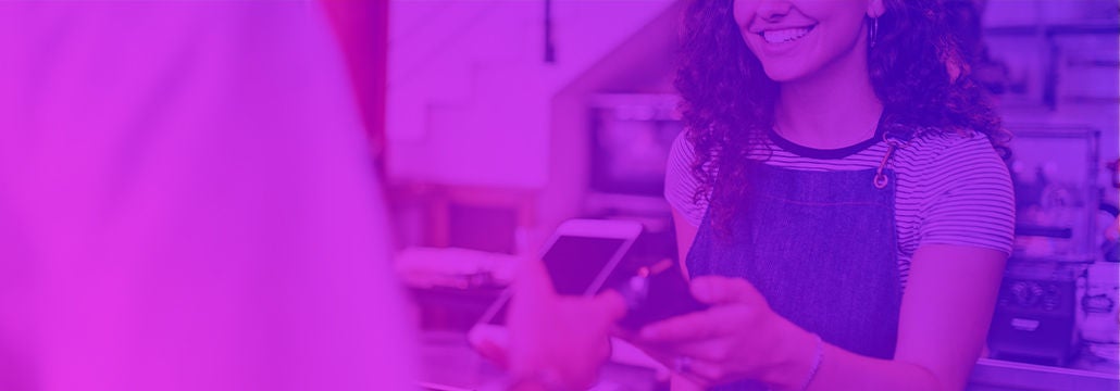 Femme barista à un système de point de vente parlant avec un client