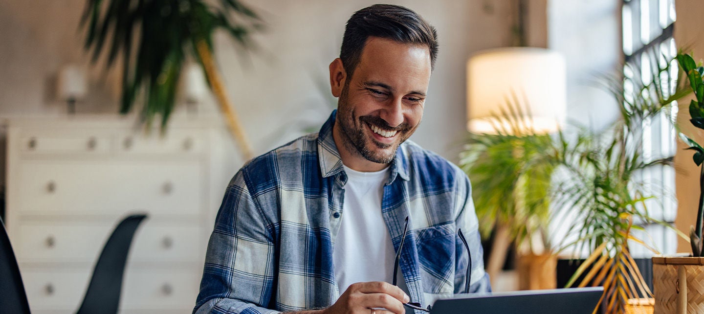 Happy man using his computer at home