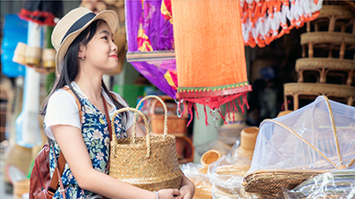 Woman in street market holding basket