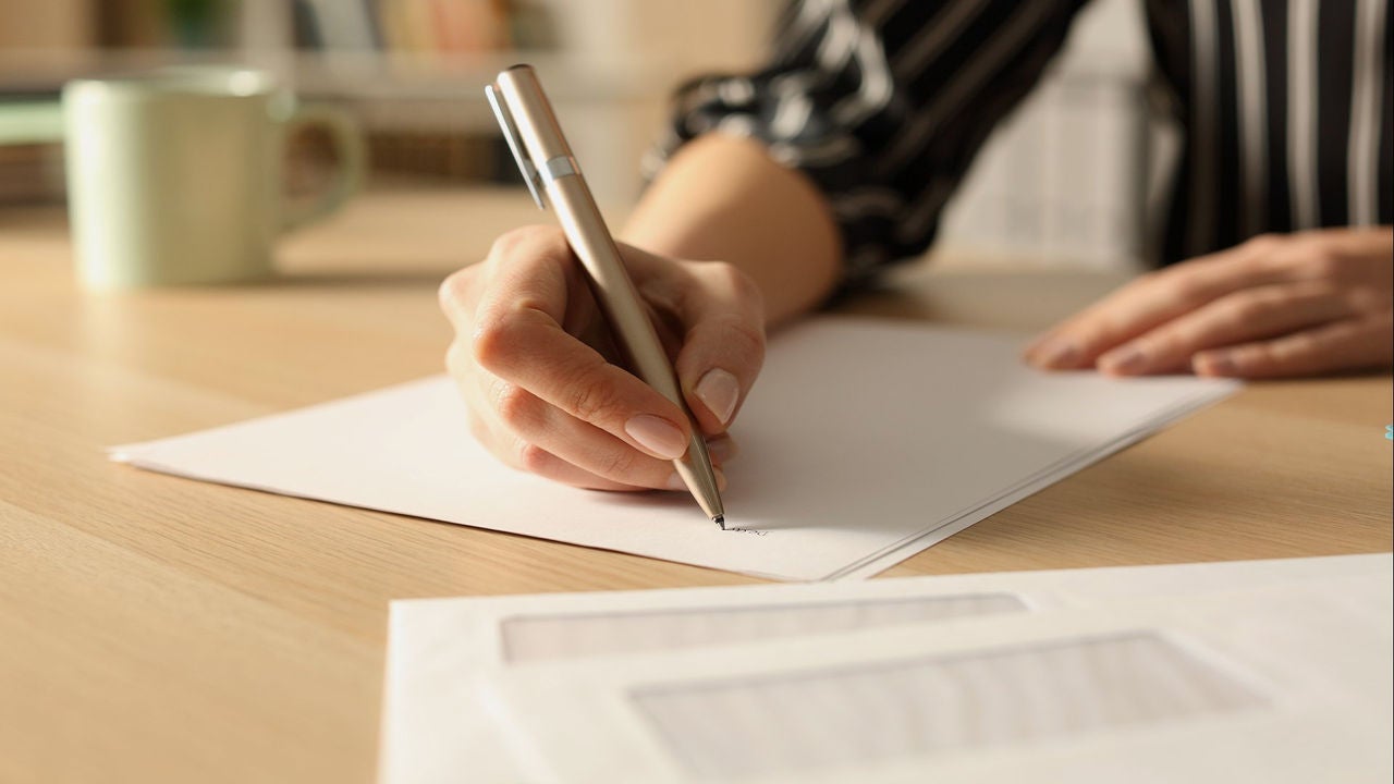 A person writing on a piece of paper