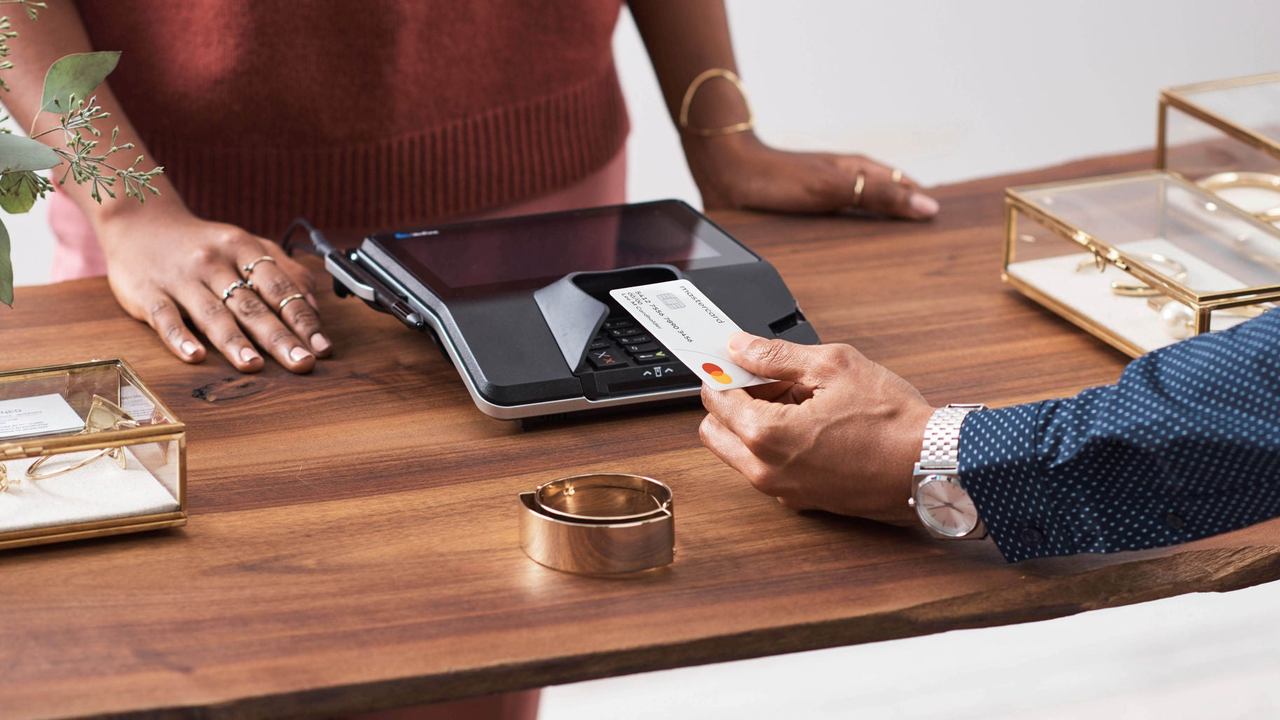 A man pays for a purchase with a contactless credit card. 
