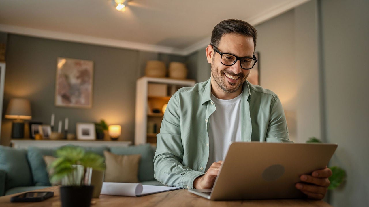 A man sitting at a table with a laptop