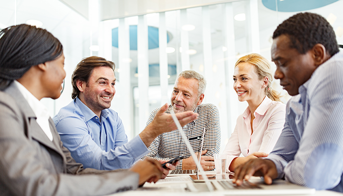 Happy business colleagues communicating during a meeting in the office