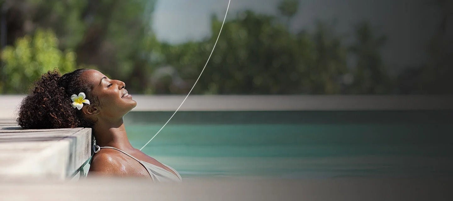 אישה נרגעת בבריכה יוקרתית.