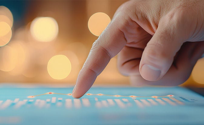 A person points at a graph displayed on a tablet, illustrating data trends and insights.