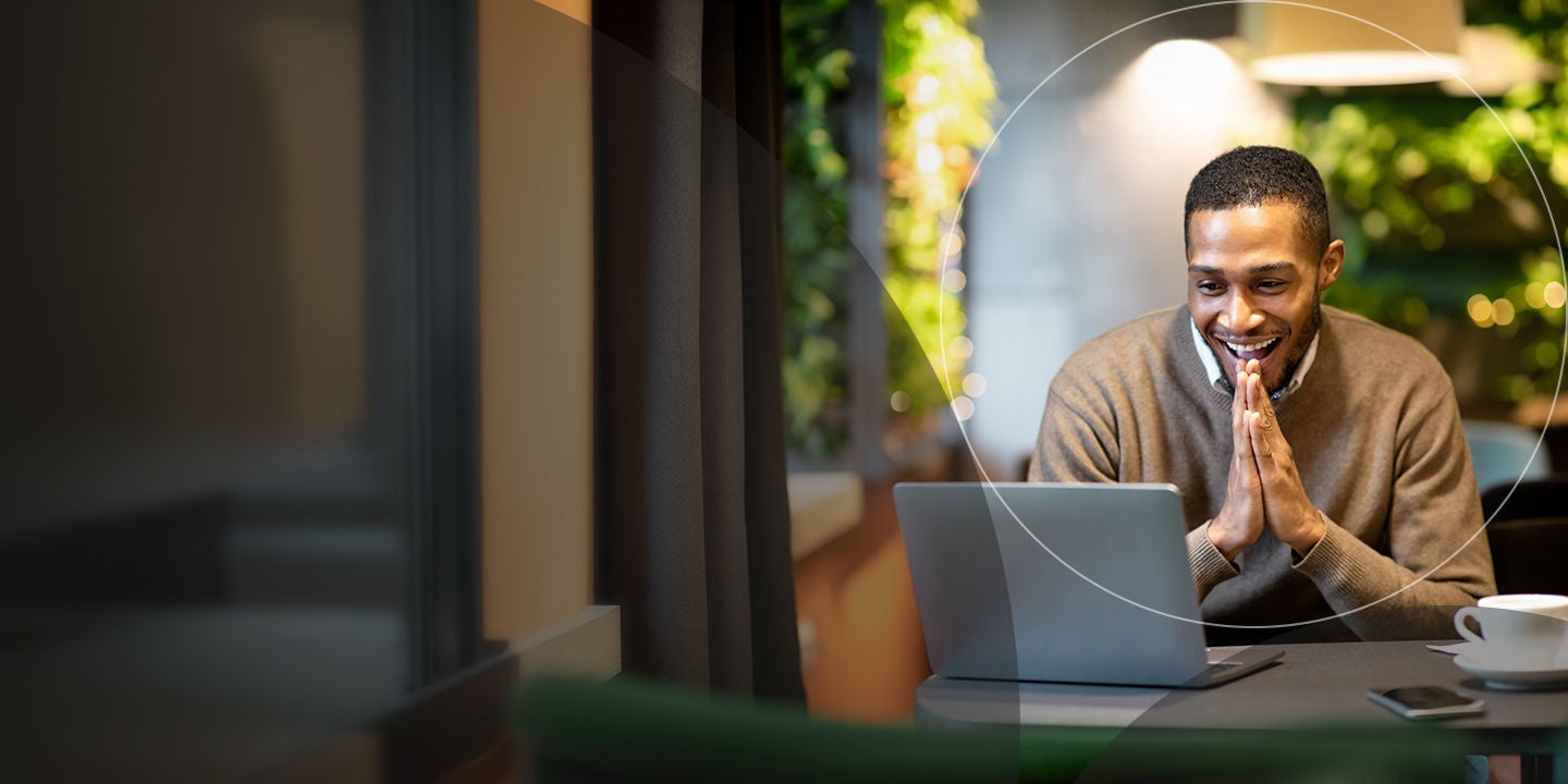 Young businessman using laptop sitting at cafe.