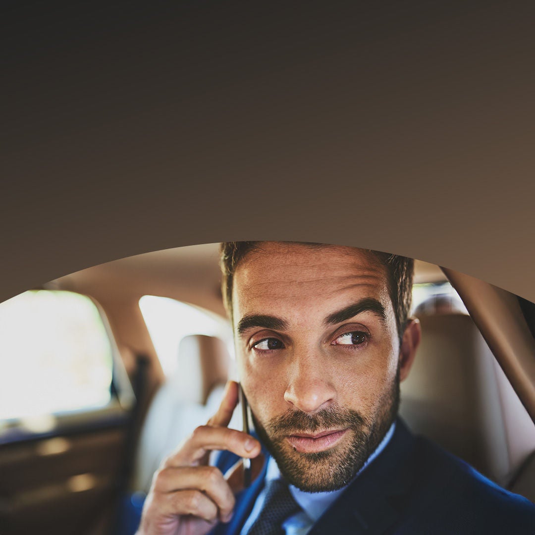 Businessman in car talking on mobile phone.