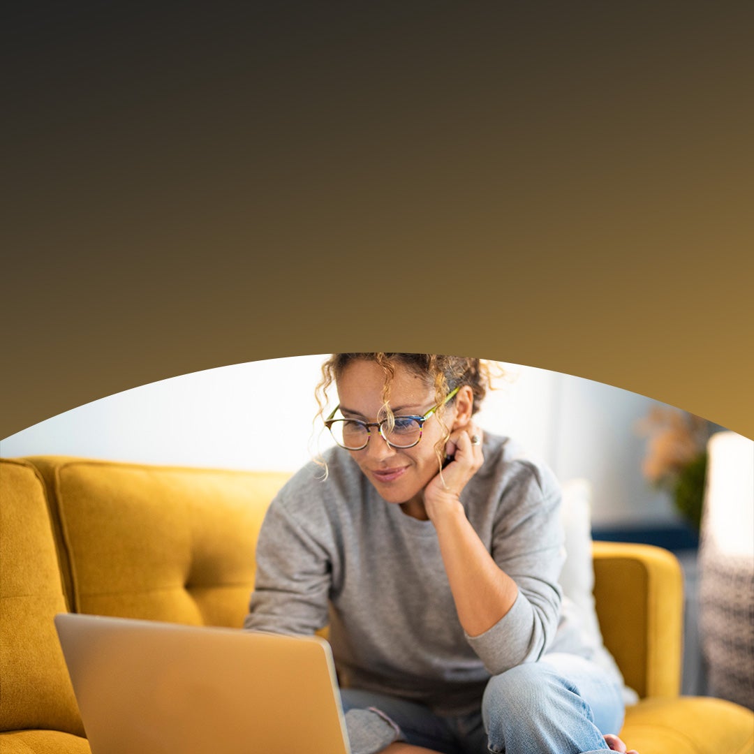 Woman sitting on couch shopping online.