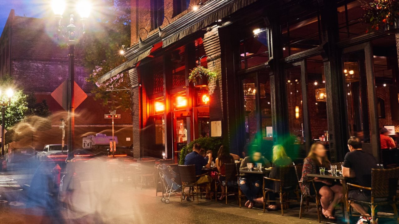 People eat dinner at an outdoor cafe at night in NYC. 