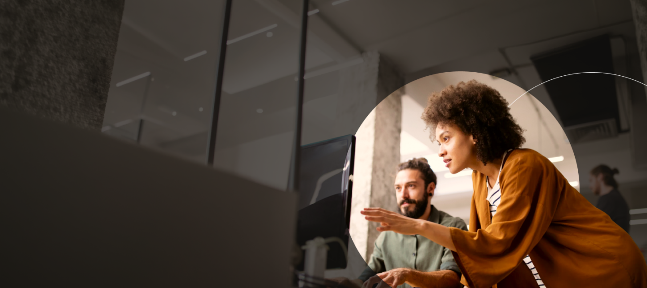 Woman and man brainstorming in front of a computer