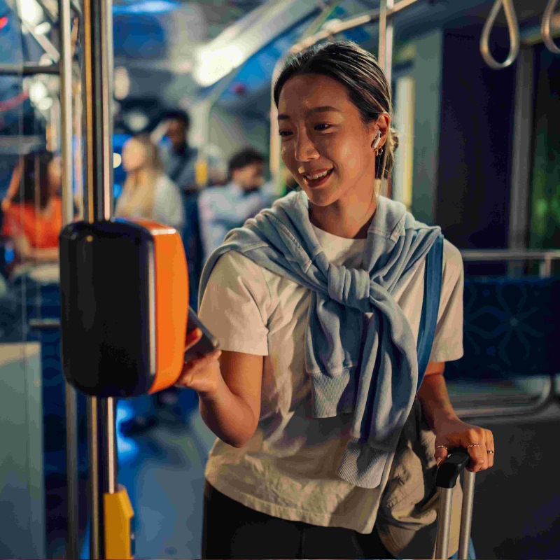 Young woman paying bus fare with contactless payment on public transport