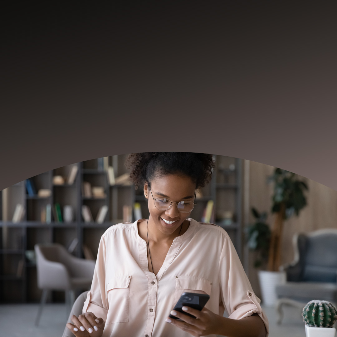 Eine Frau im rosa Mantel benutzt ein Smartphone.