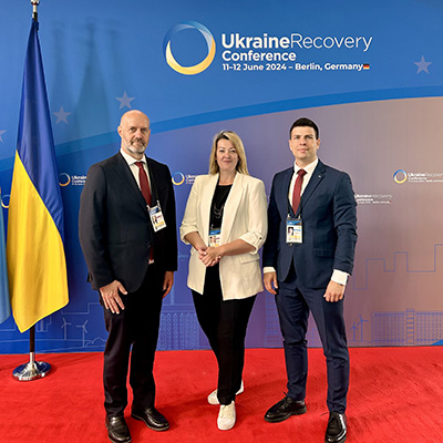 Deux hommes et une femme à la conférence sur le relèvement de l’Ukraine 