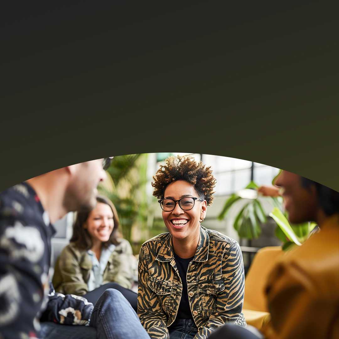 Femme noire souriante interagissant avec des collègues.