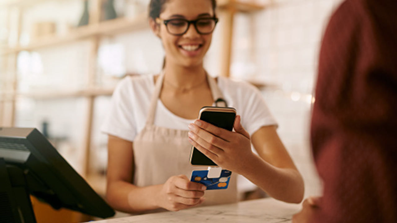 femme utilisant un téléphone au terminal de point de vente.