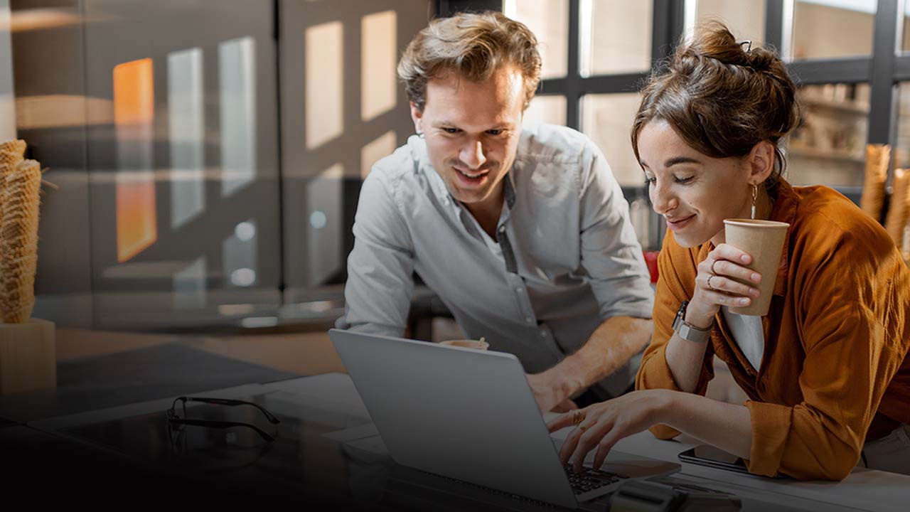 Deux professionnels sont assis à une table, engagés dans une discussion.