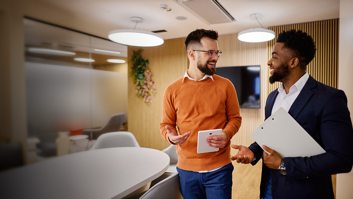 Twee collega's die op kantoor praten.