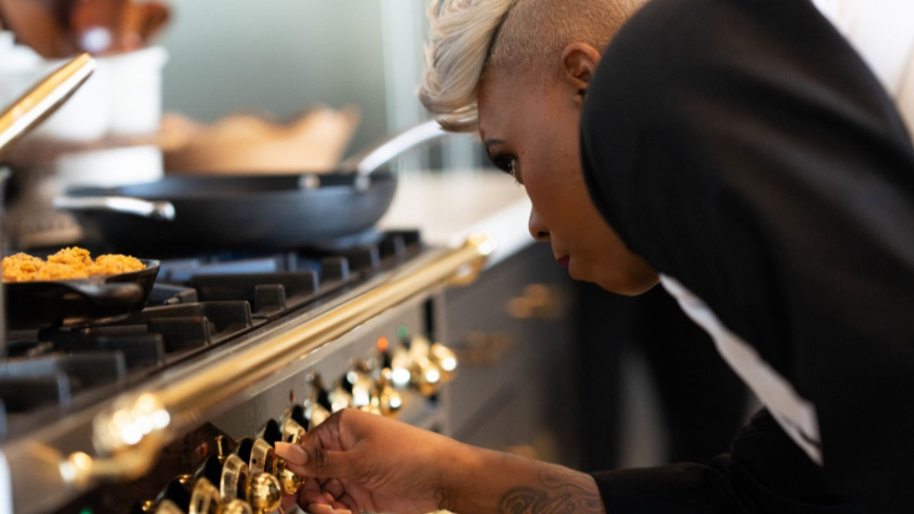 Latoya Larkin adjusts the temperature on the stove.