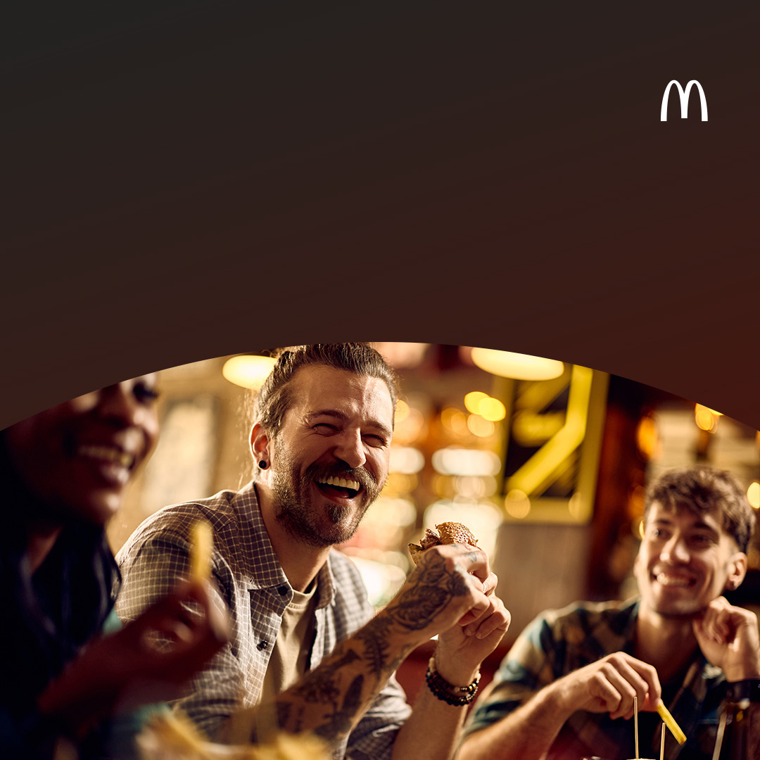 Amigos rindo e desfrutando de uma refeição no restaurante de fast food.