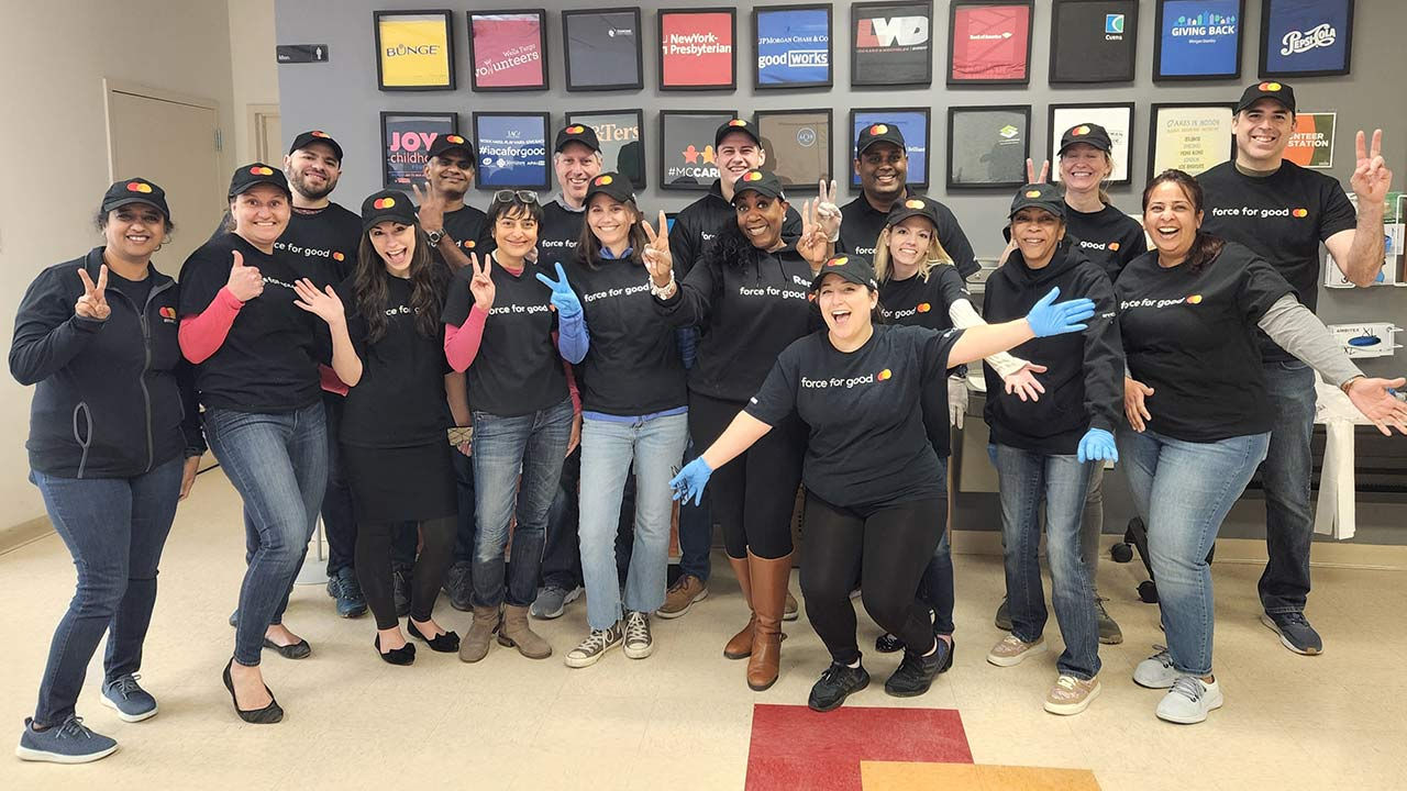 Um grupo de colegas posando para uma foto com camisetas "Force for Good"