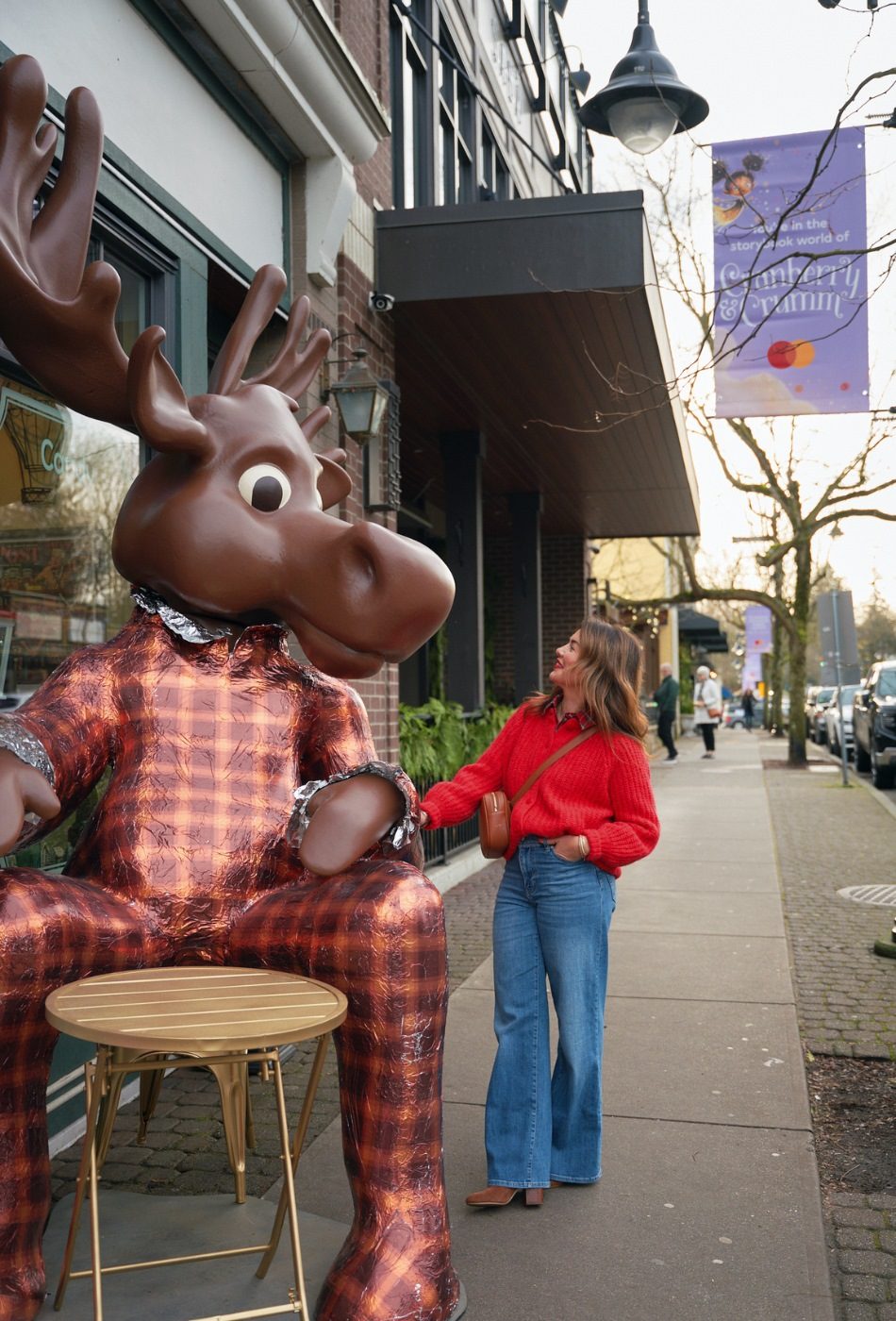 A personalidade da TV Jillian Harris posa com um alce gigante vestindo um terno xadrez no centro de Fort Langley. 