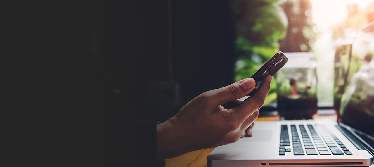 Ноутбук и телефон на столе в кафе.