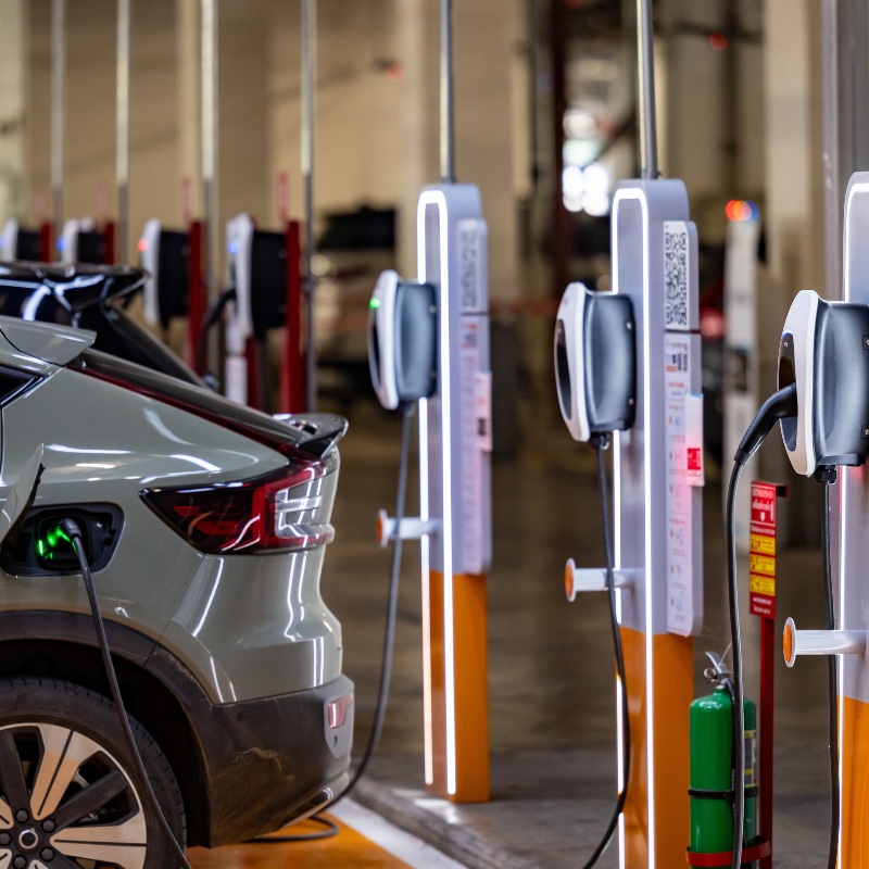 An EV being charged at a row of chargers. 