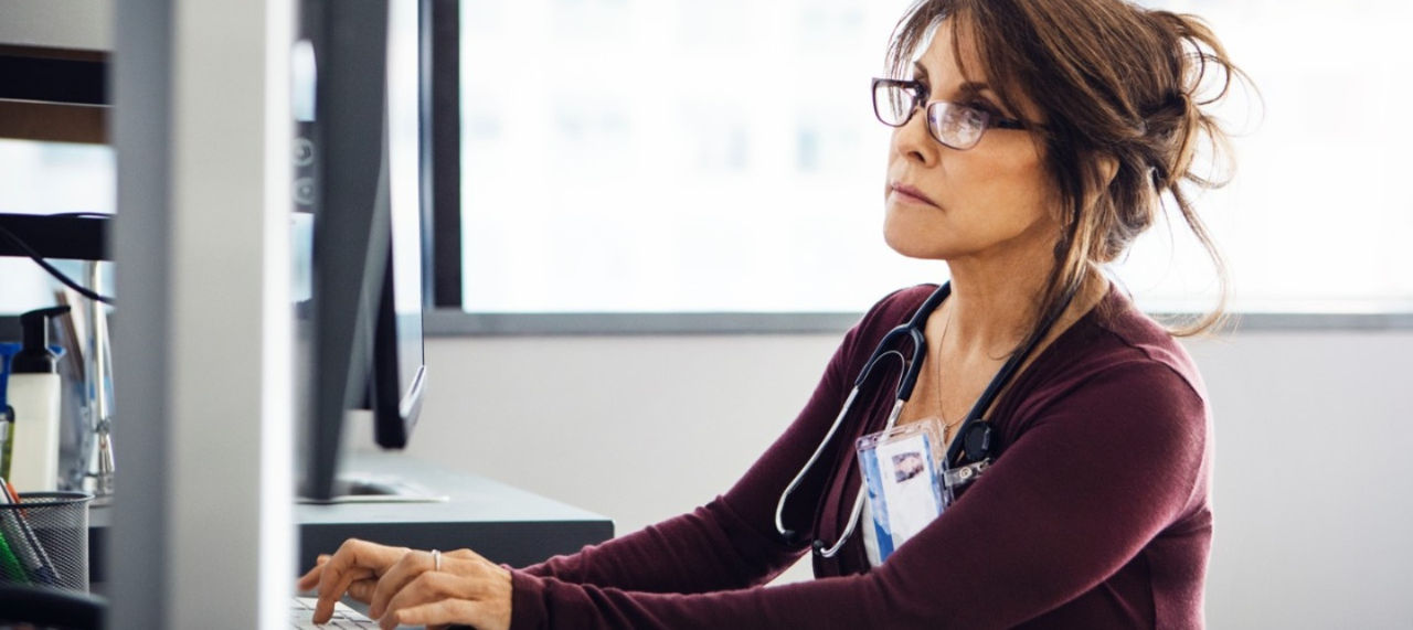A doctor looks at a computer screen. 