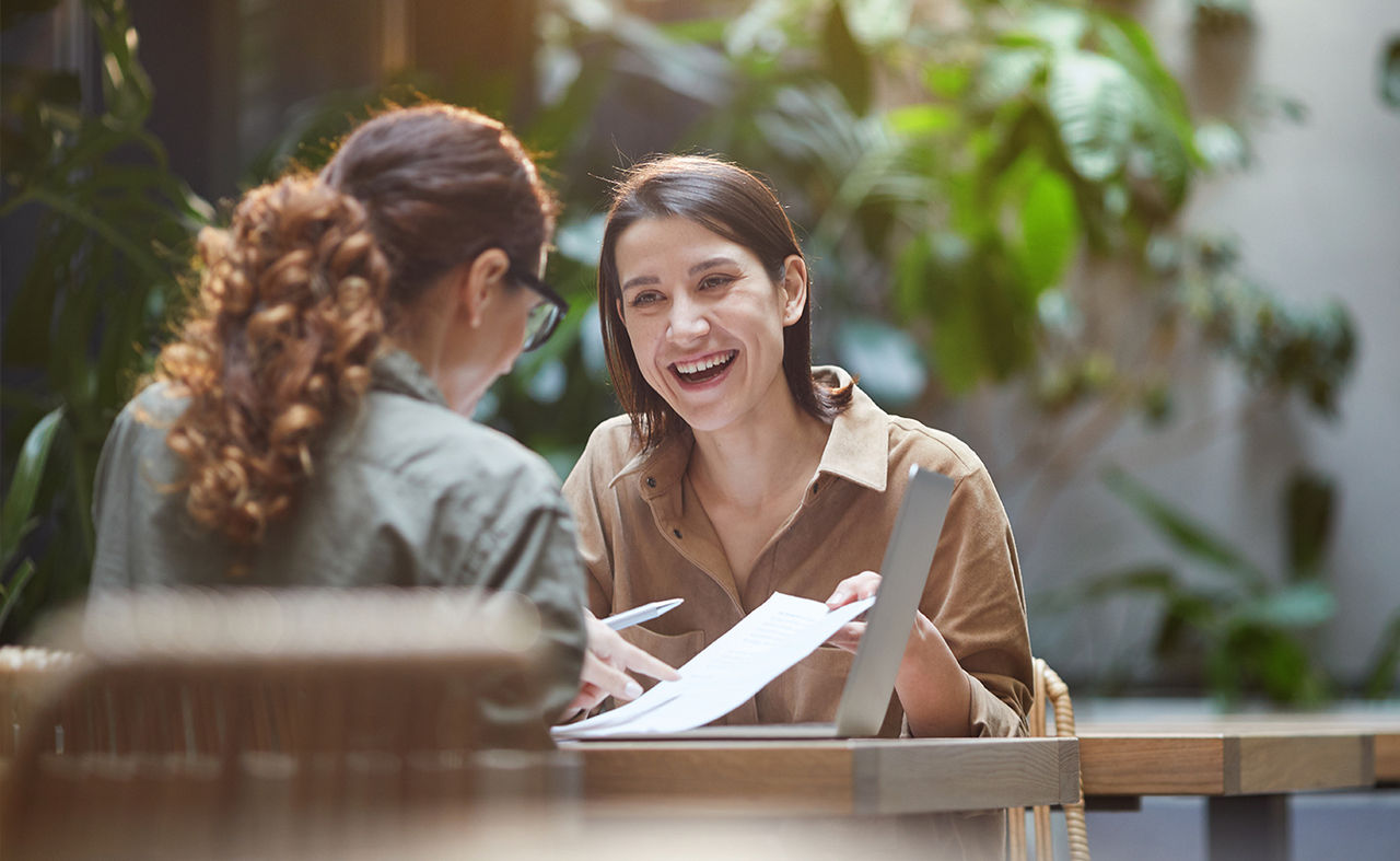 Cheerful young woman talking to friend.