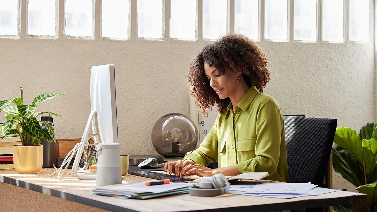 Woman in a green blouse working in an office.